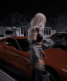 a woman standing next to a red sports car