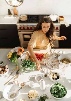 a woman standing in front of a table filled with food