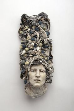 a sculpture with many objects on it's head in the shape of a woman's head