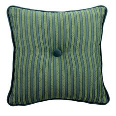 a green and blue striped pillow with a button on the front, sitting against a white background