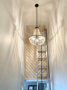 a light fixture hanging from the ceiling in a room with white walls and wood paneling