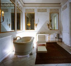 a large bathroom with a tub, mirror and rug on the floor in front of it