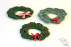 three crocheted wreaths with bows on them