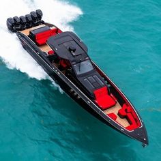 a motor boat is in the middle of the water with red seats on it's back end