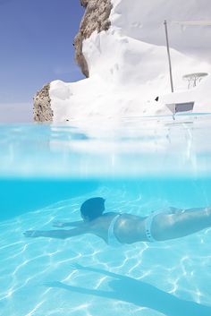 a bottle floating in the water next to a mountain