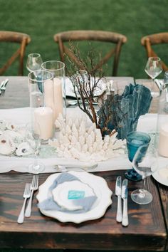 the table is set with candles, plates and napkins