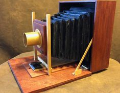 an old fashioned wooden camera on display with some sort of tape dispenser