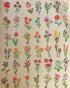 an embroidered wall hanging with colorful flowers on it