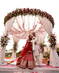 a newly married couple posing for a photo in front of an outdoor wedding ceremony set up