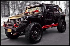 a black and red jeep parked in front of a building