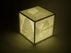 an illuminated cube with mountains and trees on it