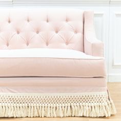 a pink couch sitting on top of a hard wood floor