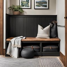 a wooden bench with two pictures on the wall above it and a blanket draped over it