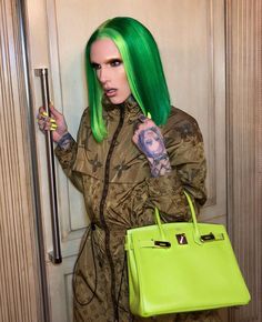 a woman with green hair is holding a handbag