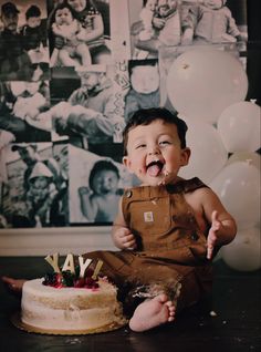 a young boy sitting in front of a cake