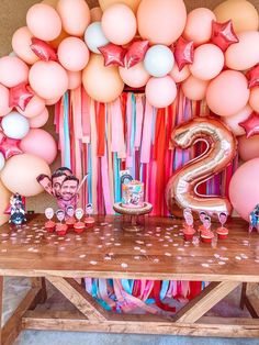 a table with balloons, streamers and decorations for a two year old birthday party