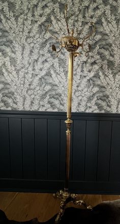 a floor lamp is standing in front of a wallpapered room with blue walls