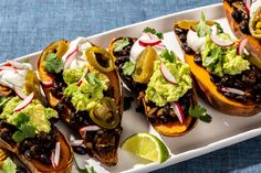 several tacos are arranged on a white platter