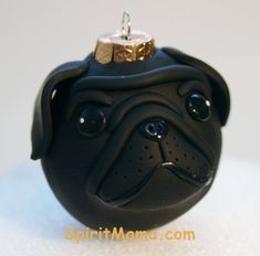 a black pug dog ornament with a diamond ring on it's nose