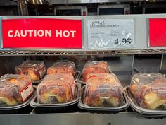 there are many baked goods on display in the case at this store, and one is labeled caution hot