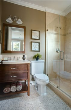 a white toilet sitting next to a wooden cabinet in a bathroom under a shower head