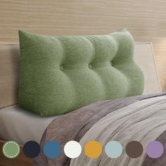 there is a bed with green pillows on it and many different colored circles around the headboard