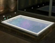 a large bath tub sitting in the middle of a bathroom next to a tiled floor