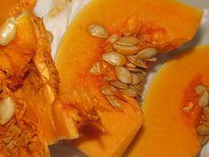 some pumpkins are cut in half and sitting on a white plate with other food items