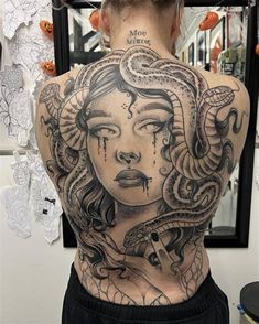 the back of a woman's body with tattoos on her upper and lower back