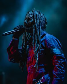 a man with dreadlocks holding a microphone