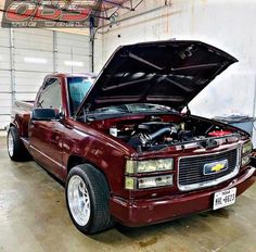 a maroon pick up truck with its hood open