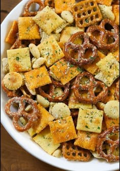 a white bowl filled with cheesy crackers and pretzels