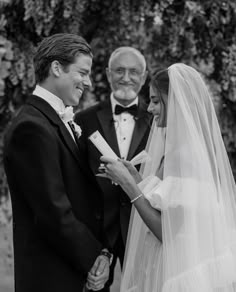 the bride and groom are smiling at each other as they hold hands during their wedding ceremony