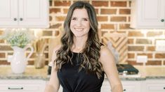 a woman standing in front of a kitchen counter