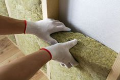 a person in white gloves working on insulation