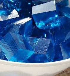 a bowl filled with blue glass blocks on top of a table