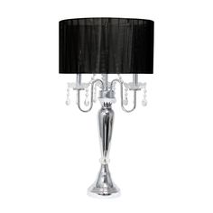 a table lamp with a black shade on it and a silver base, sitting next to a white wall