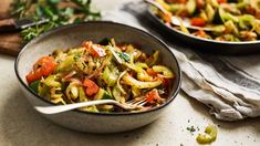 two bowls filled with vegetables on top of a table