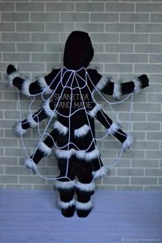 a person wearing a costume made out of fake furs and wires, standing in front of a brick wall