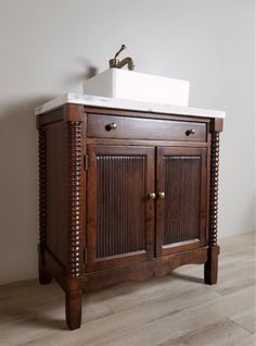 a wooden cabinet with a white sink in it