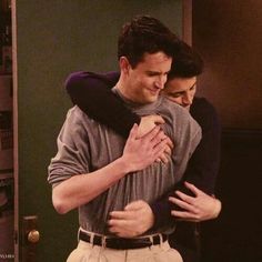 two people hugging each other in a room