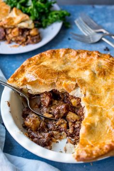 a close up of a pie on a plate with a fork and knife in it