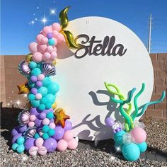 there is a sign that says stella on it and balloons in the shape of mermaids