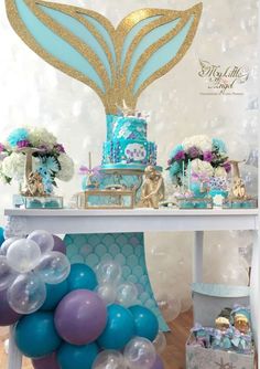 a table with balloons, cake and decorations on it