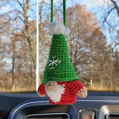 a crocheted christmas decoration hanging from the dashboard of a car