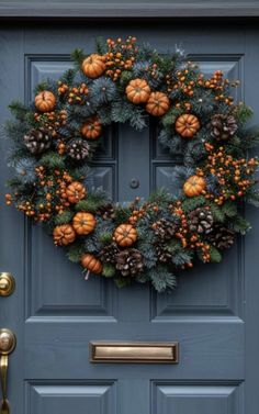 a blue front door with a wreath and pine cones hanging on it's side