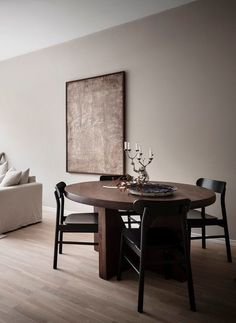 a living room with a couch, table and chair next to a large painting on the wall