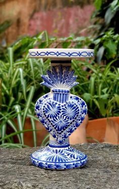 a blue and white vase sitting on top of a rock