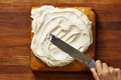 someone is spreading icing on a piece of bread with a knife to spread it