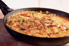 an omelet in a skillet on a wooden table